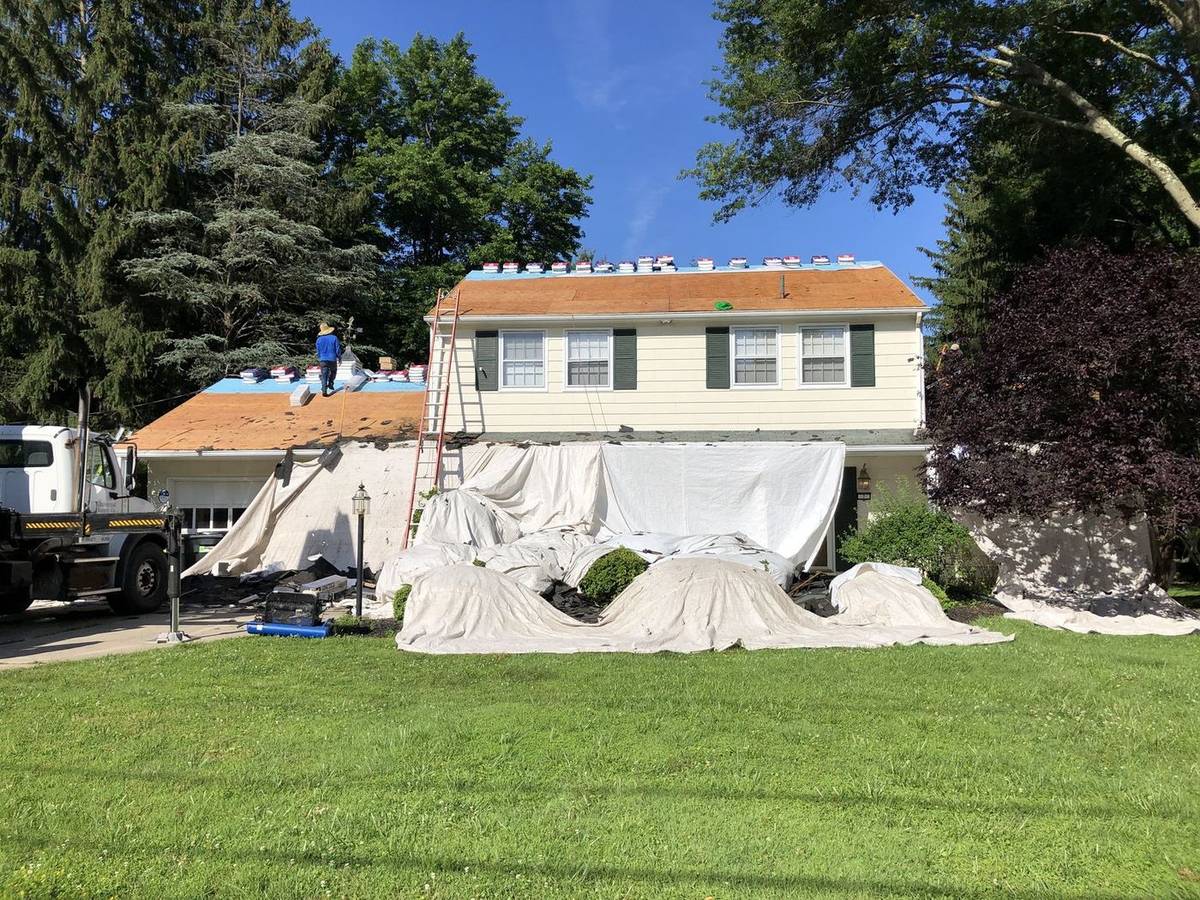 A house mid roof replacement with protective tarps